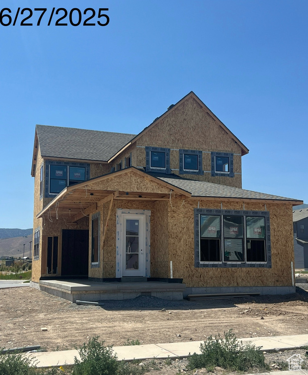 Unfinished property with roof with shingles and a porch