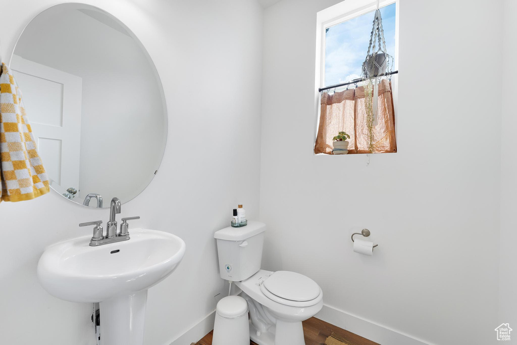 Half bath featuring baseboards and wood finished floors