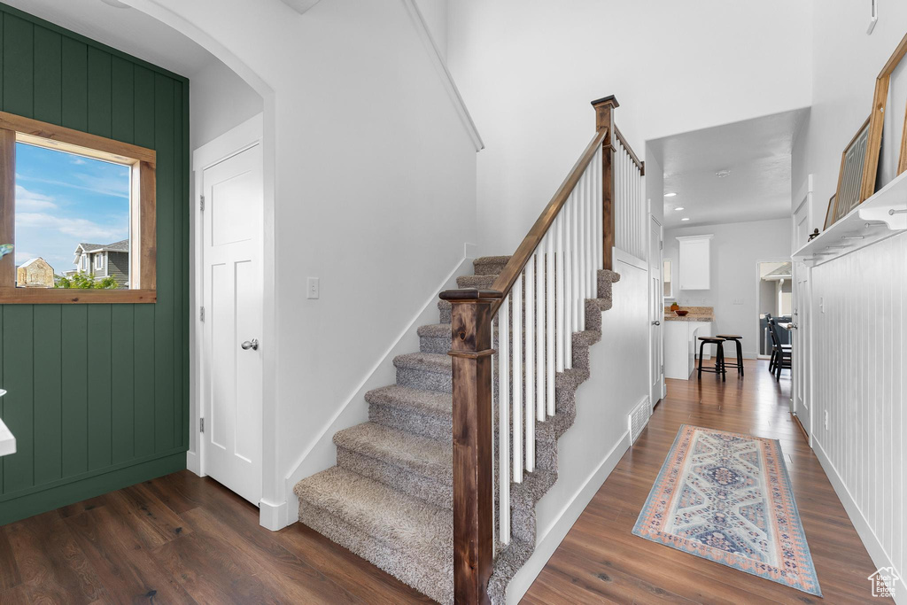 Stairs with wood finished floors and arched walkways