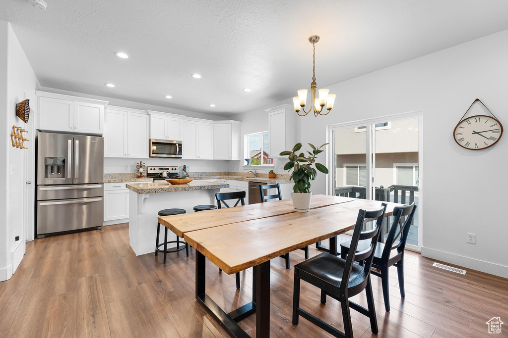 Dining area featuring a chandelier, recessed lighting, and wood finished floors