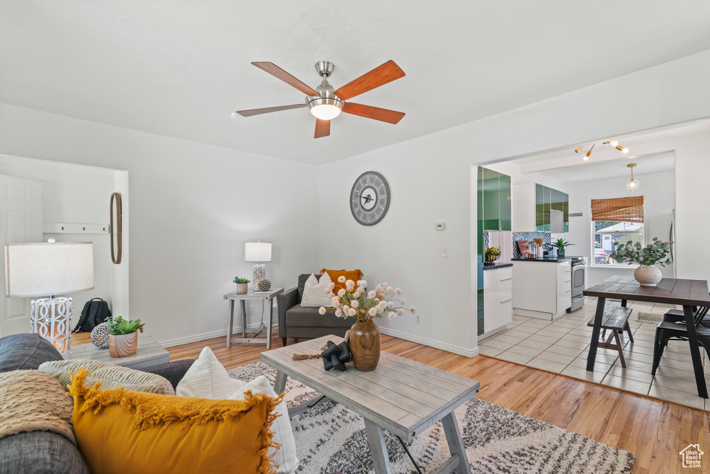 Living area featuring a ceiling fan and light wood-type flooring