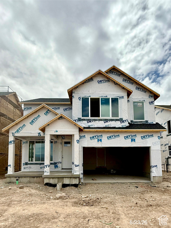 Unfinished property featuring an attached garage, a porch, and dirt driveway