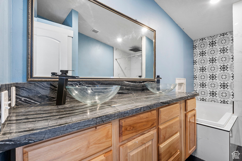 Bathroom with double vanity, a garden tub, and a shower