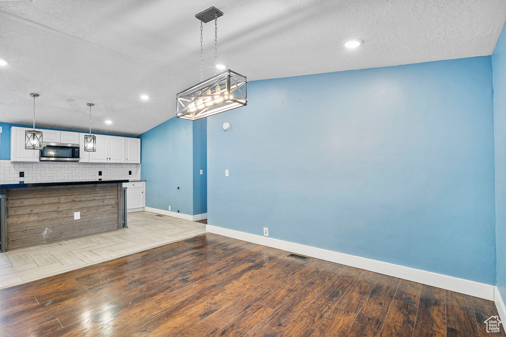 Unfurnished living room with light wood-style floors, recessed lighting, and a textured ceiling