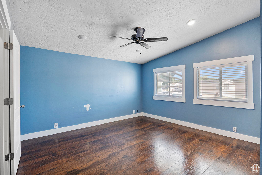 Unfurnished room with vaulted ceiling, a textured ceiling, ceiling fan, and wood finished floors