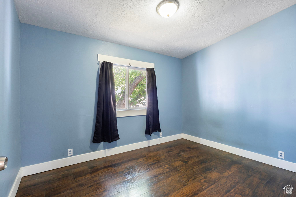 Unfurnished room featuring wood finished floors and a textured ceiling