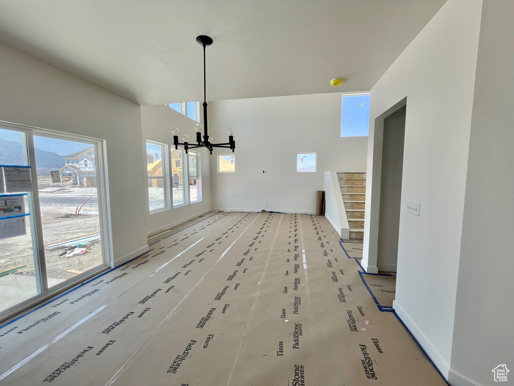 Unfurnished dining area with a chandelier and stairway