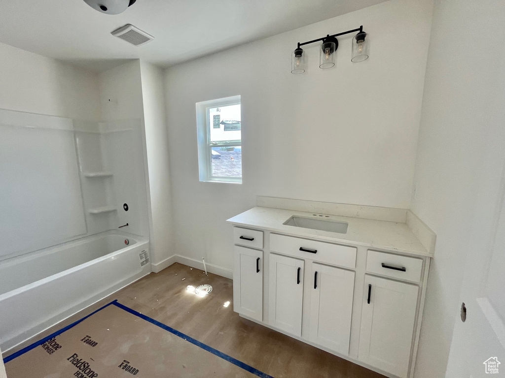 Full bath with vanity, shower / bathtub combination, and wood finished floors