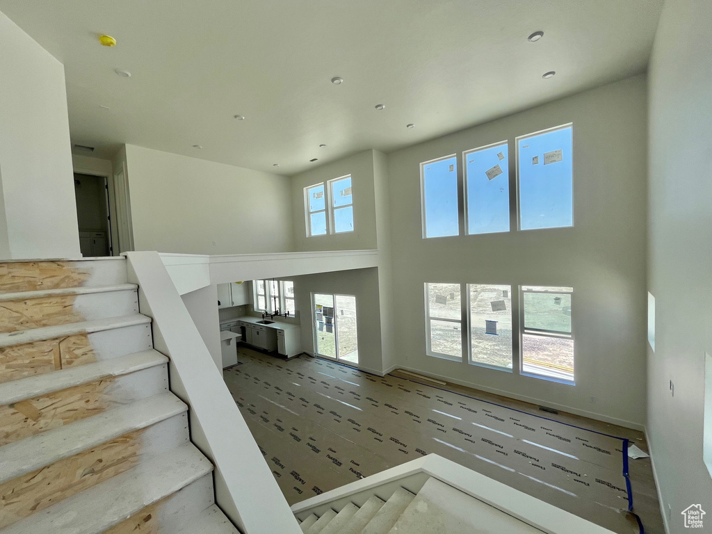Stairway featuring a towering ceiling