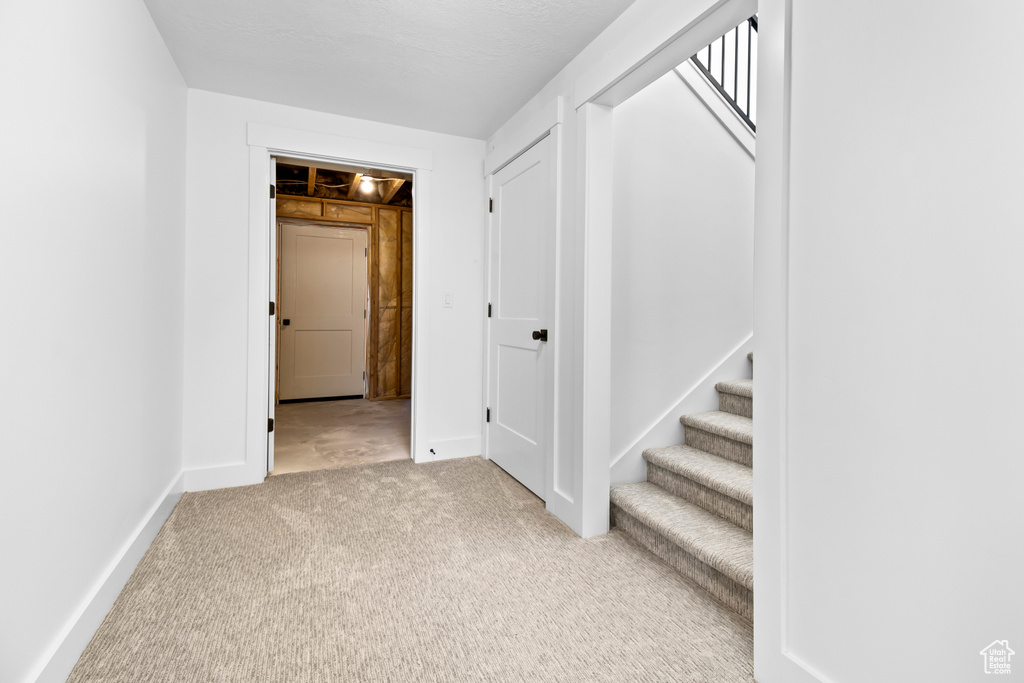 Hallway featuring carpet and stairs