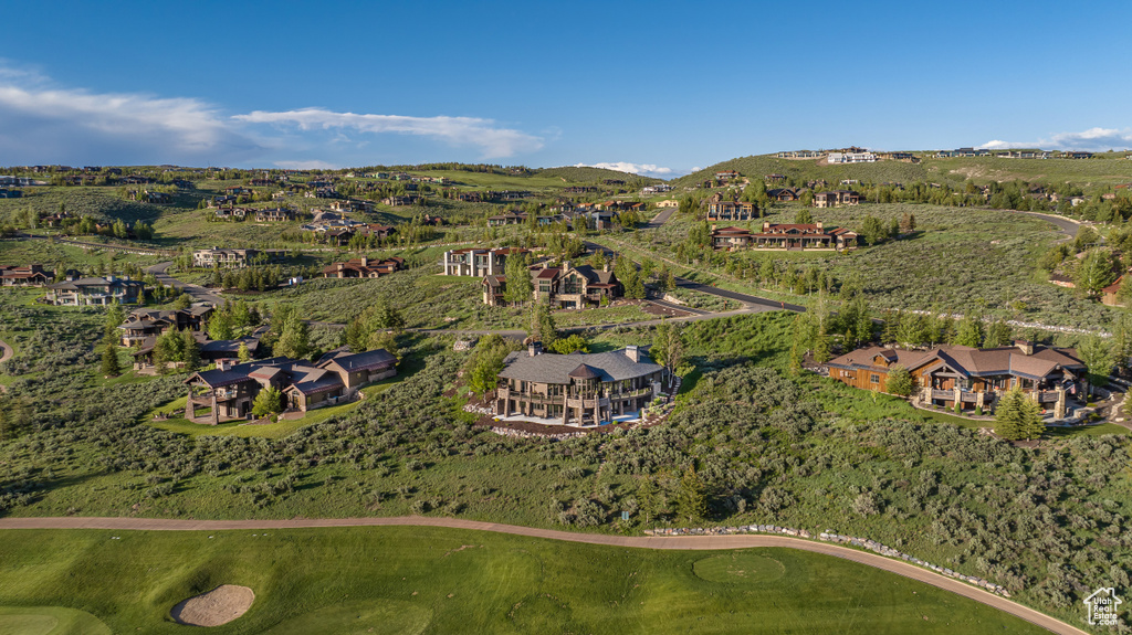 Aerial view of property and surrounding area with a golf club and nearby suburban area