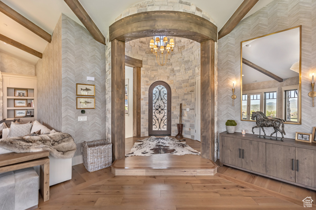 Entryway featuring a chandelier, wood-type flooring, and arched walkways