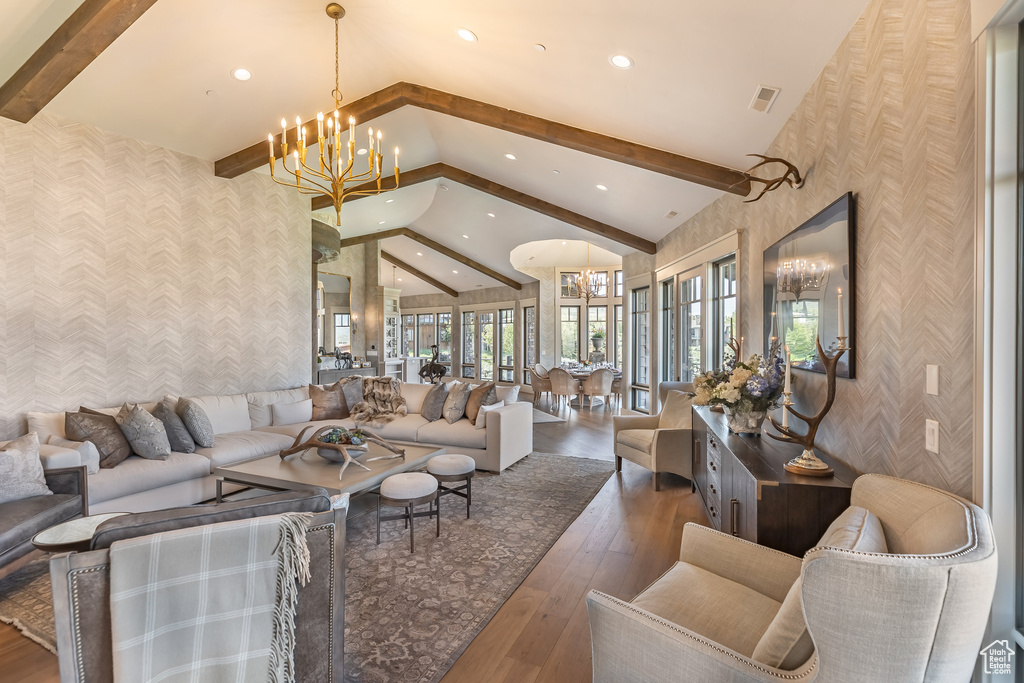 Living room with wallpapered walls, beamed ceiling, a chandelier, recessed lighting, and hardwood / wood-style floors