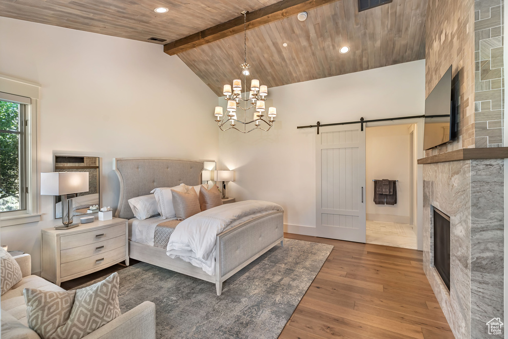 Bedroom featuring a barn door, hardwood / wood-style flooring, a chandelier, recessed lighting, and wood ceiling