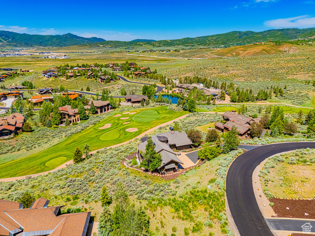 Aerial view of residential area featuring a mountainous background and a local golf course