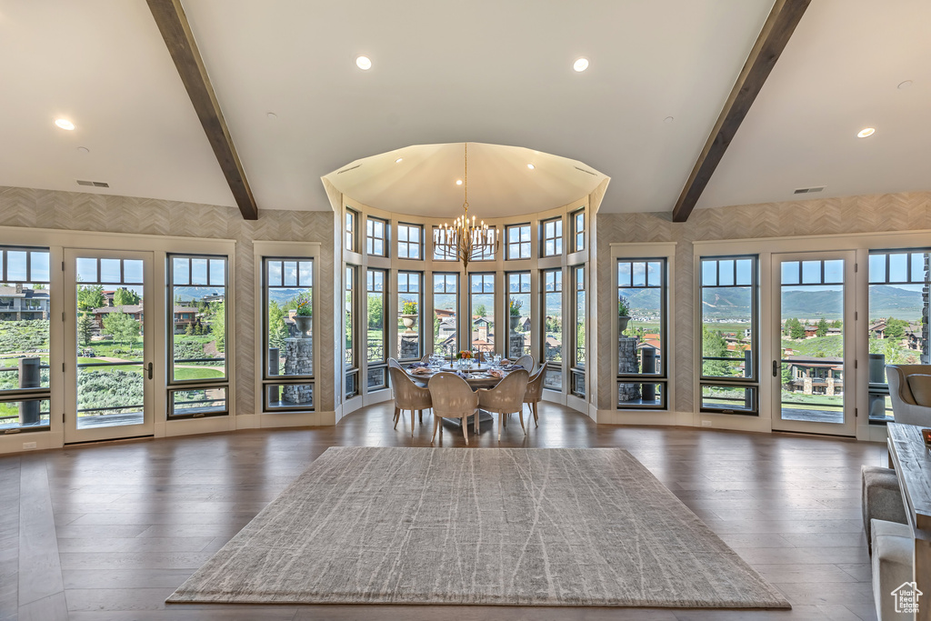 Dining area with beam ceiling, plenty of natural light, a chandelier, recessed lighting, and wood finished floors