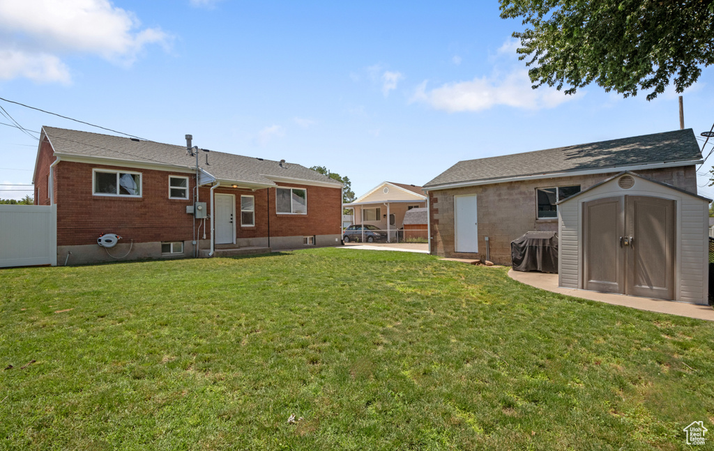 Back of property with a storage shed, brick siding, and entry steps