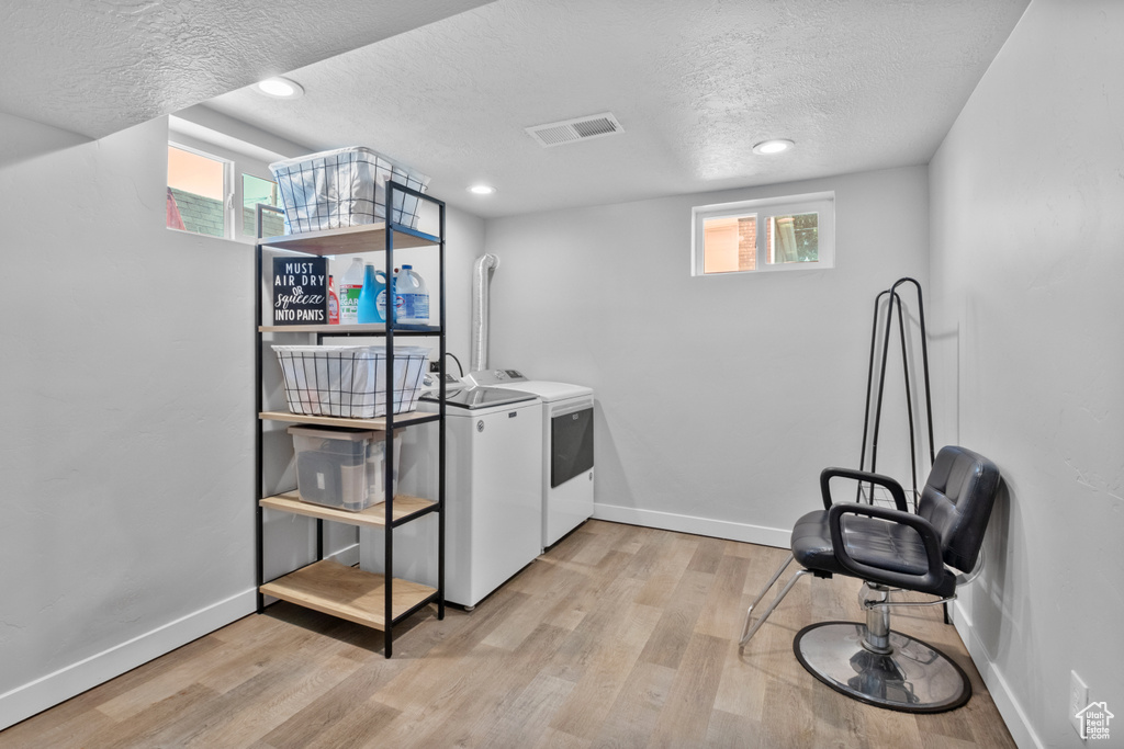 Kitchen featuring washer and dryer, a textured ceiling, light wood-style flooring, and recessed lighting