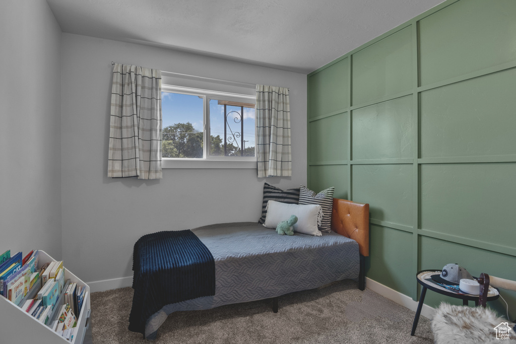 Bedroom featuring carpet and baseboards