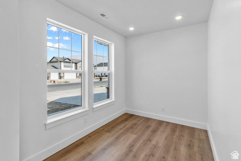Unfurnished room with wood finished floors and recessed lighting