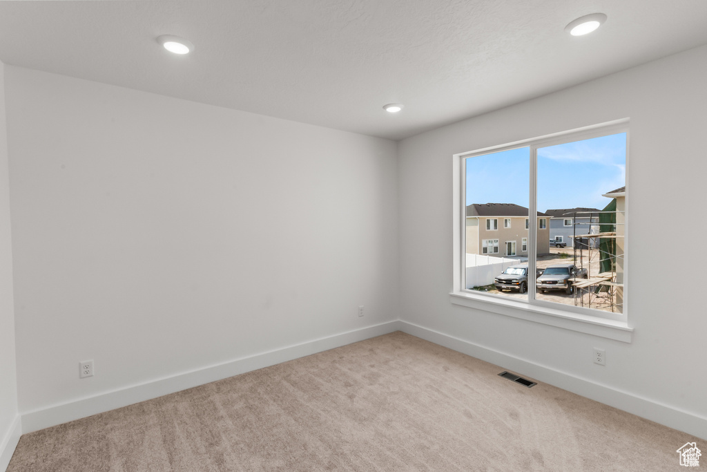 Carpeted empty room with recessed lighting