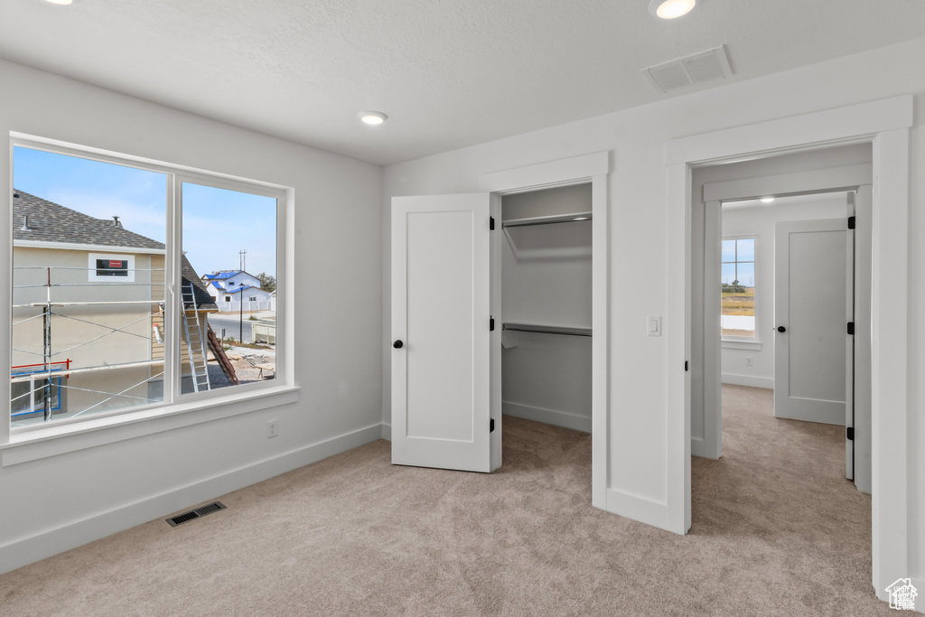 Unfurnished bedroom with carpet floors, a spacious closet, recessed lighting, and a closet