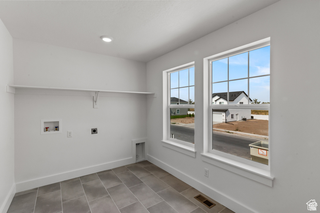 Washroom featuring electric dryer hookup, washer hookup, and tile patterned floors