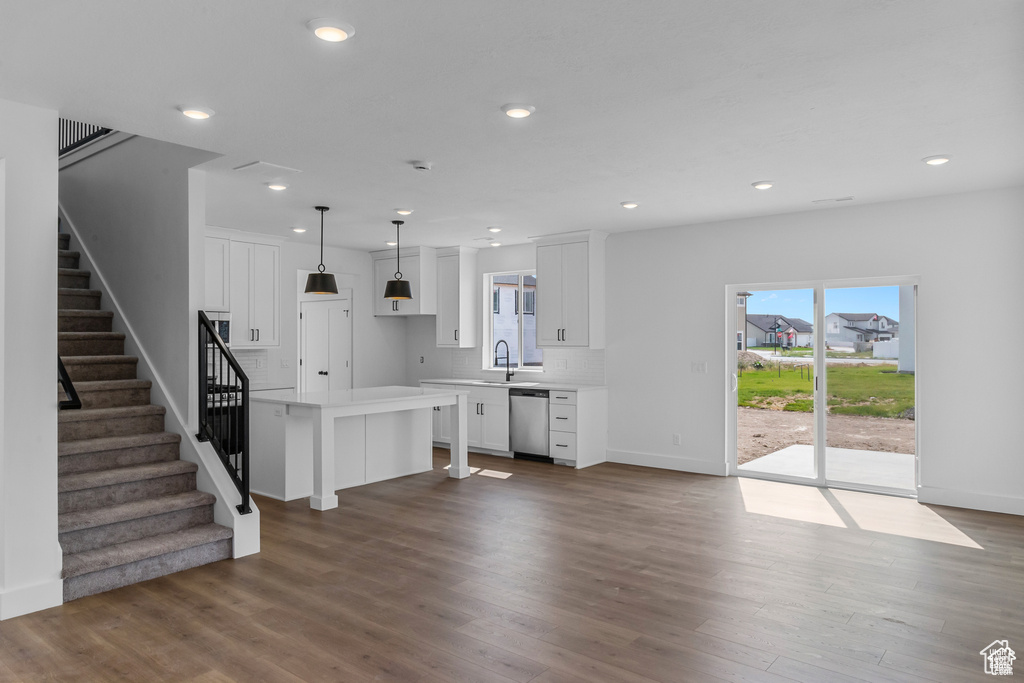Kitchen featuring dishwasher, light countertops, white cabinetry, wood finished floors, and recessed lighting