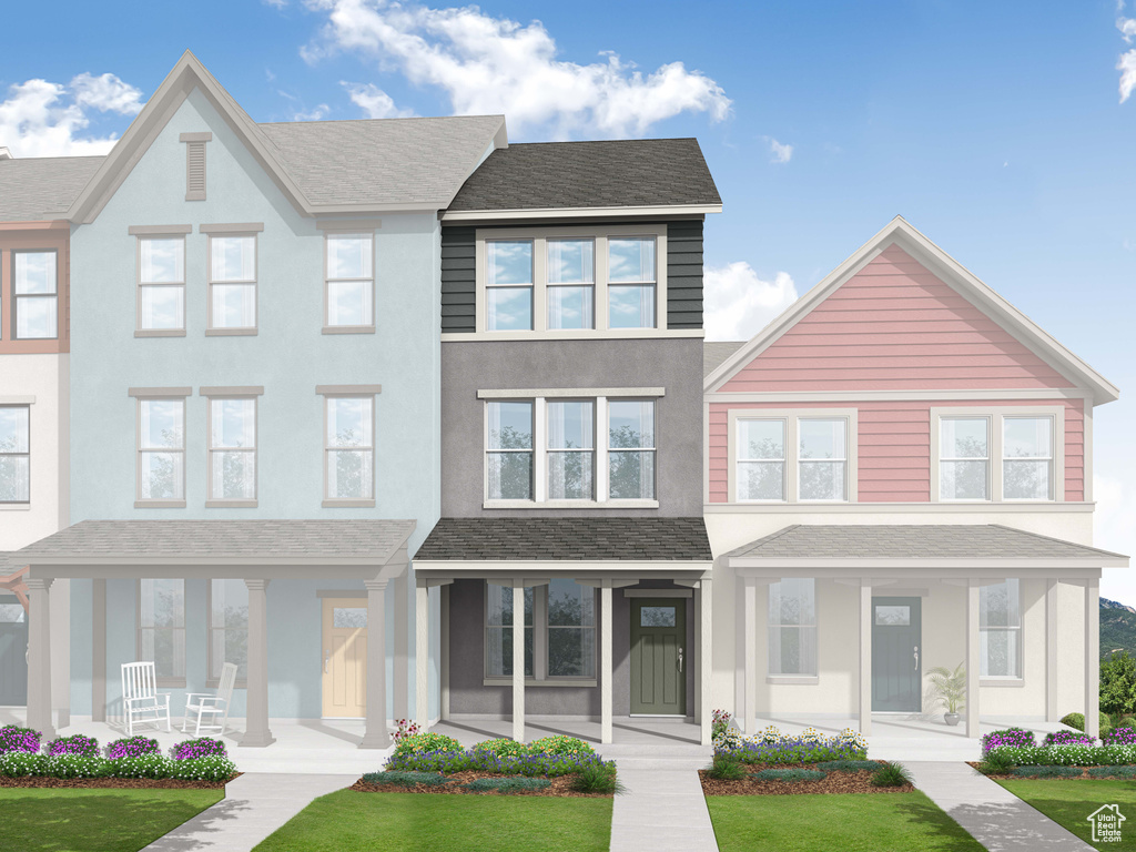 Townhome / multi-family property featuring a front yard and stucco siding