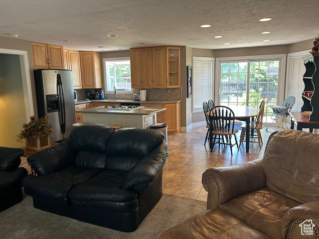 Living room featuring recessed lighting, a textured ceiling, and light tile patterned flooring