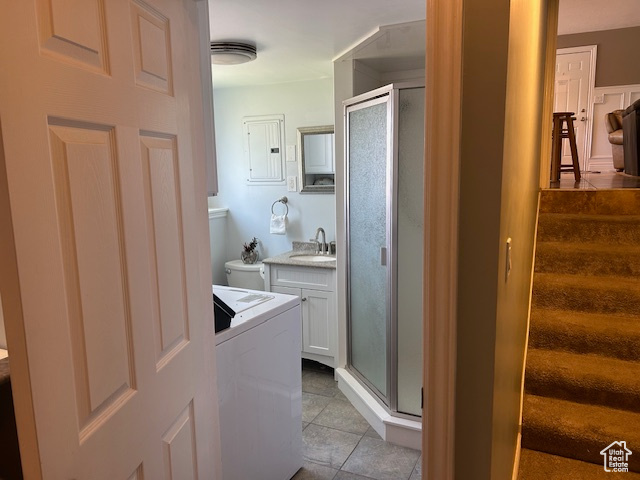 Laundry room featuring washer / clothes dryer, cabinet space, electric panel, and light tile patterned floors