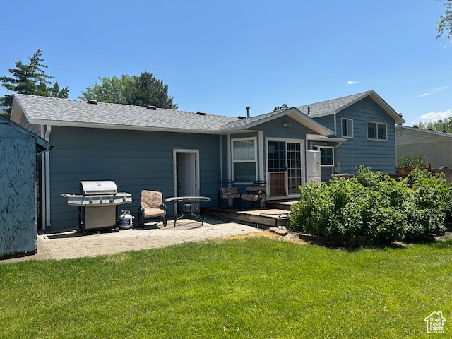 Back of property featuring a patio area and a lawn