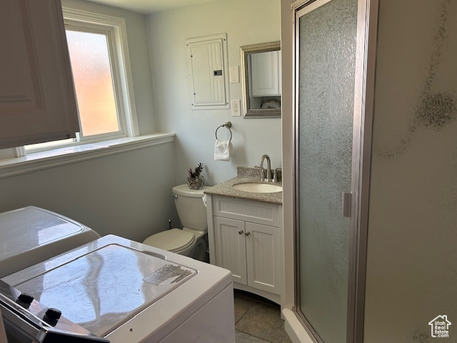 Bathroom with washer / clothes dryer, electric panel, a shower stall, vanity, and tile patterned floors