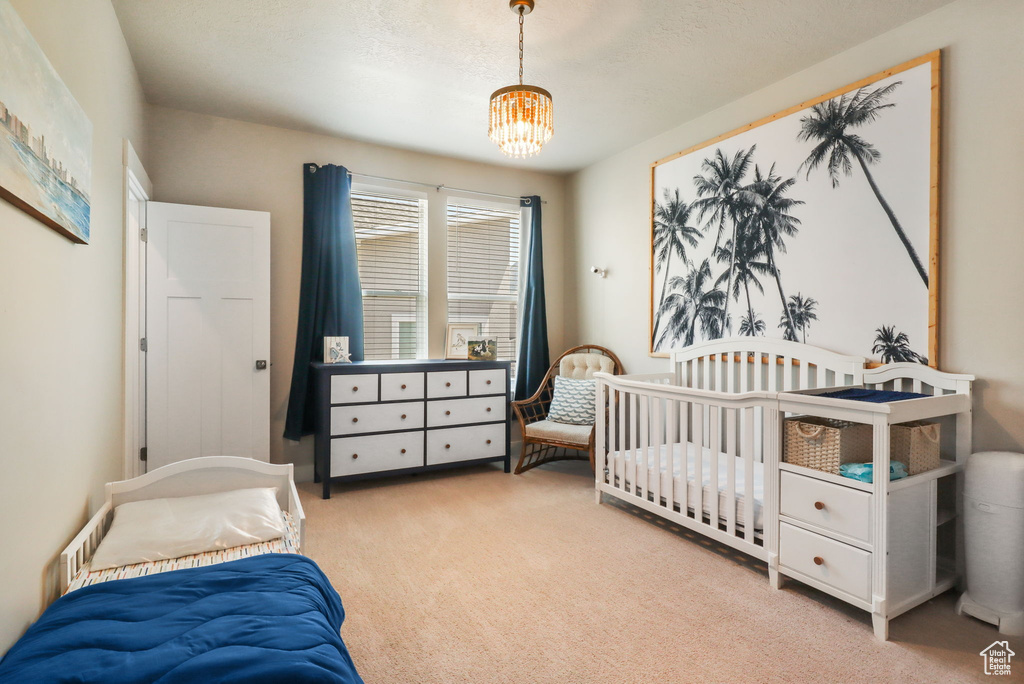 Carpeted bedroom with a chandelier