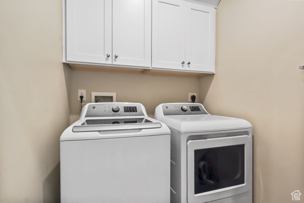Laundry room with separate washer and dryer and cabinet space