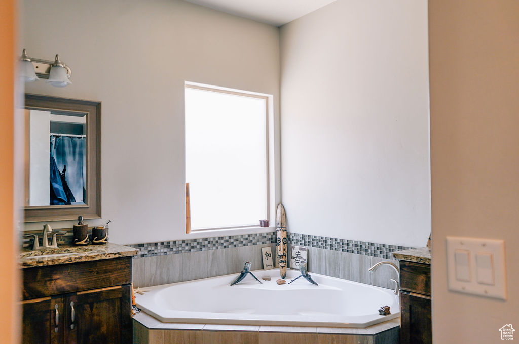 Bathroom featuring vanity and a bath