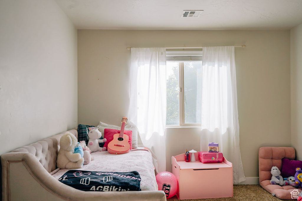 Bedroom with multiple windows and carpet