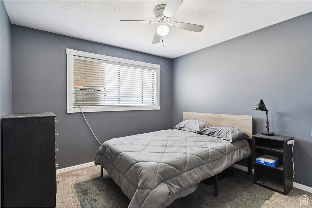 Carpeted bedroom featuring baseboards and a ceiling fan