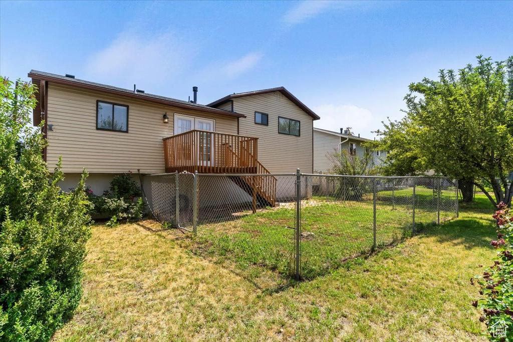 Back of house with a wooden deck and stairs