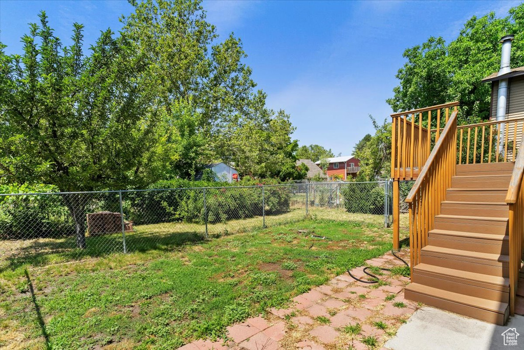 Fenced backyard with stairway and a deck