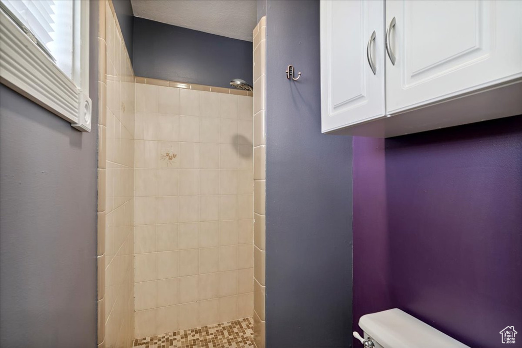 Bathroom with toilet and tiled shower