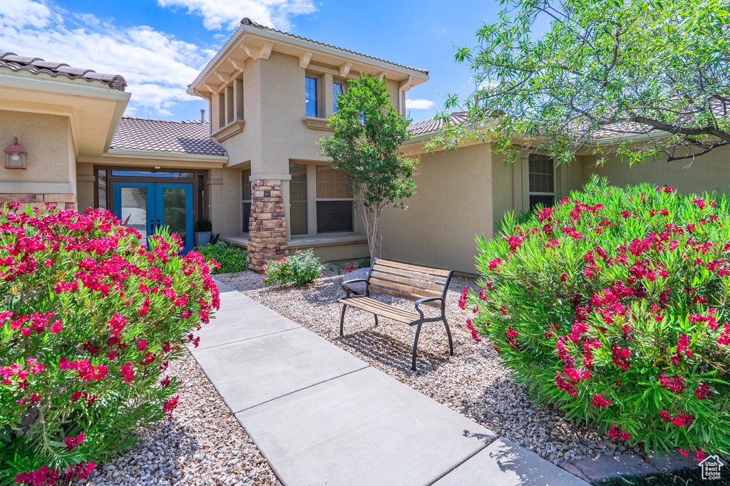Entrance to property with stucco siding, a tiled roof, and french doors