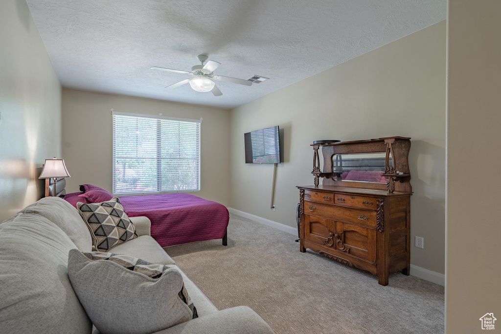 Bedroom featuring carpet flooring, a textured ceiling, and ceiling fan