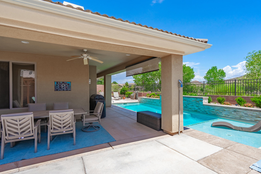 View of pool featuring ceiling fan, a patio area, a fenced backyard, and outdoor dining area