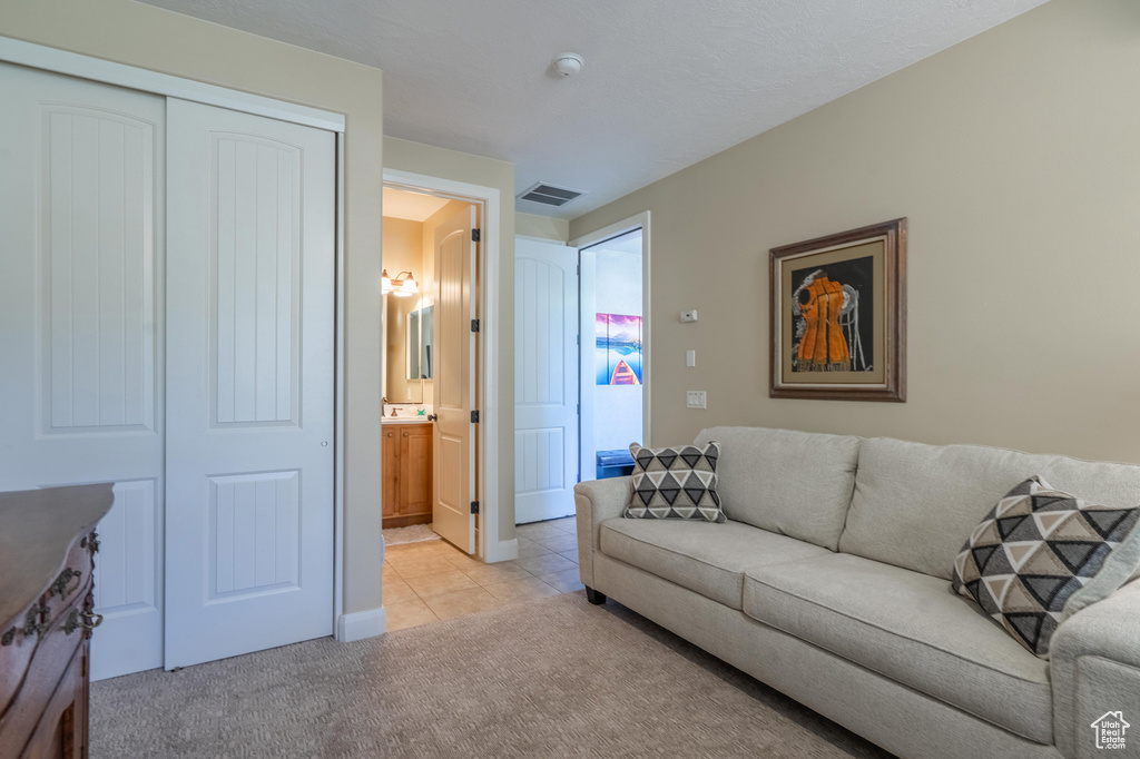 Living area featuring light carpet and light tile patterned floors