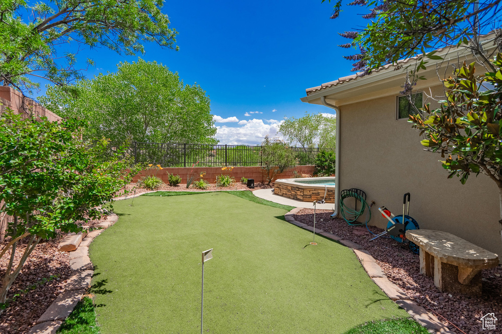Fenced backyard with a putting green