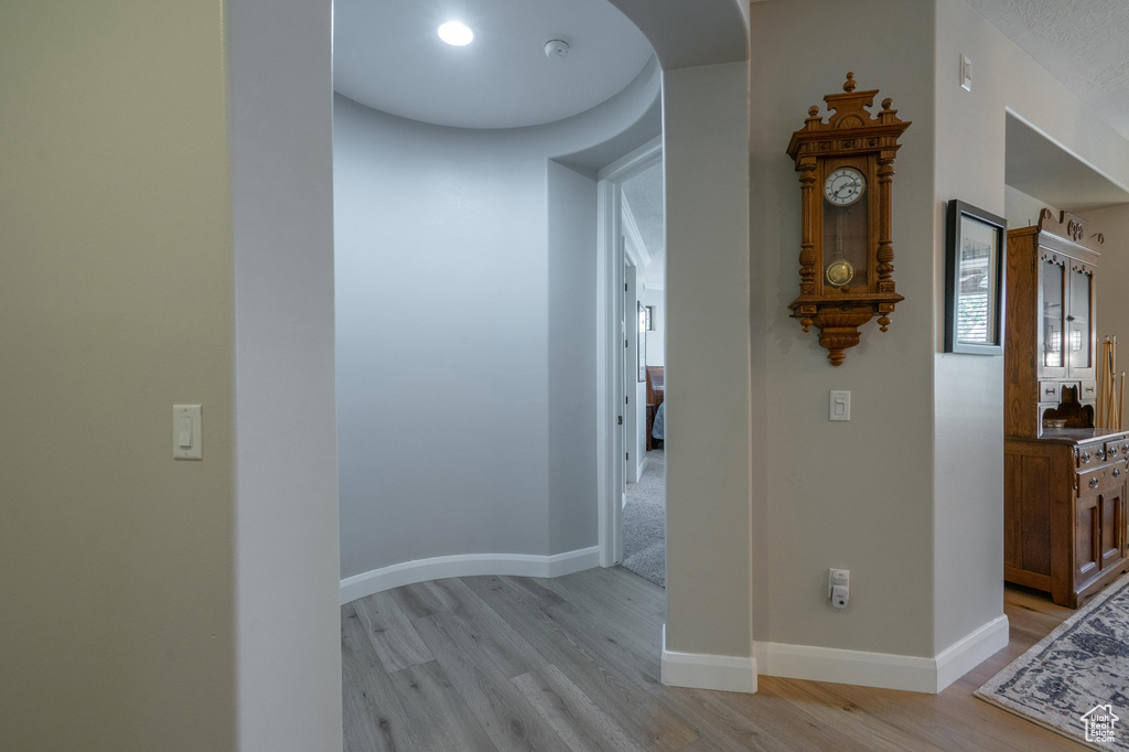 Hallway featuring light wood-style flooring and arched walkways