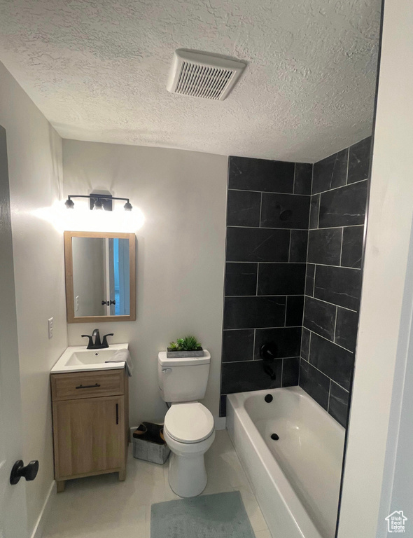 Bathroom featuring vanity, shower / bath combination, and a textured ceiling