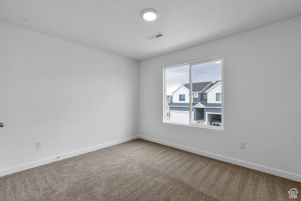 Carpeted empty room with baseboards
