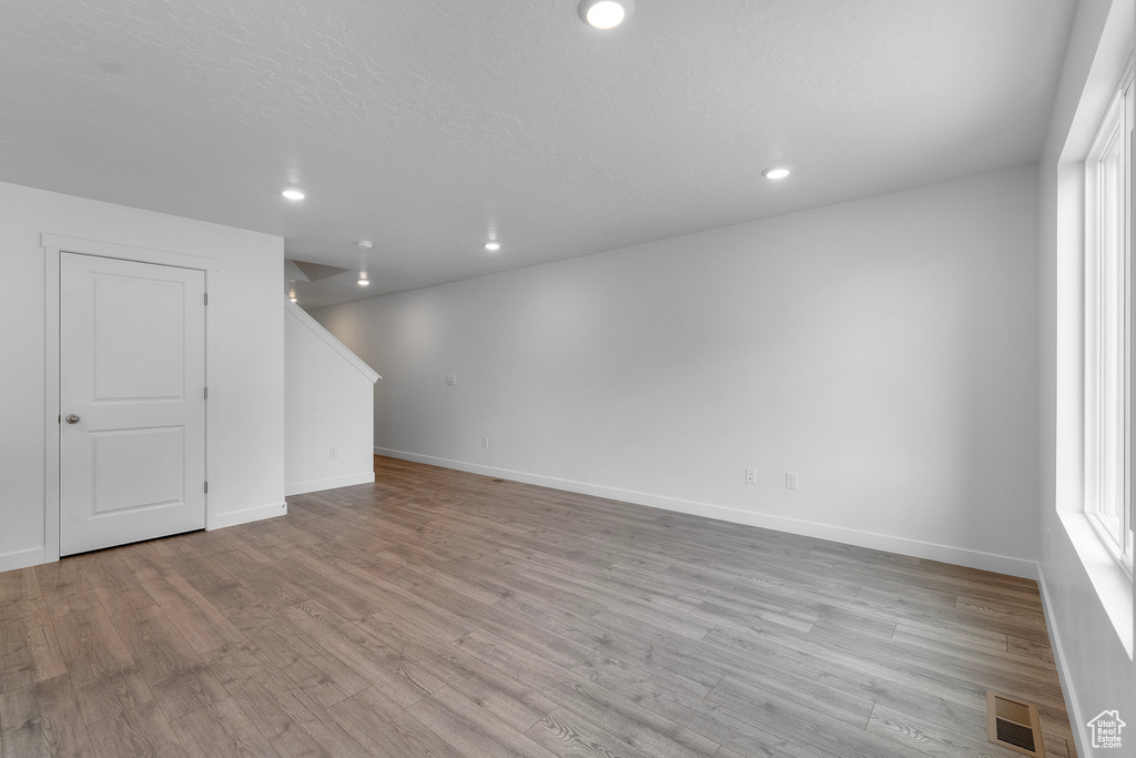 Below grade area featuring light wood finished floors and recessed lighting